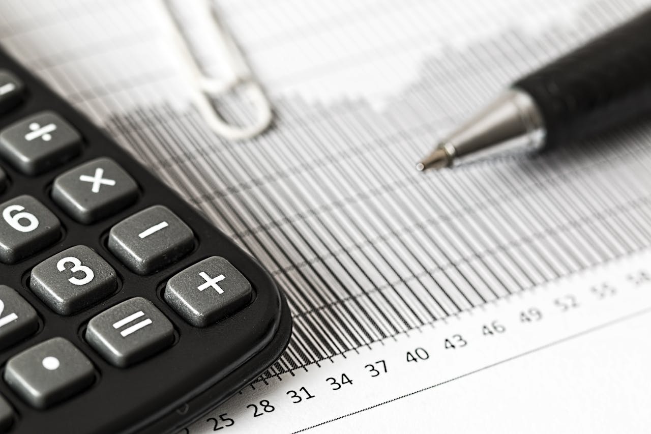 contact-img-02 Close-up of a calculator and pen on a bar graph, representing finance and accounting.